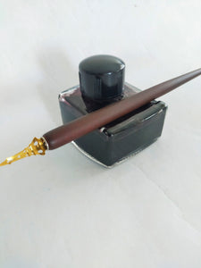 Vintage inkwell/pen rest, filled with black ink