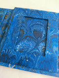 Triple blue an. closeupd gold marbled frame, peacock pattern. close up shot