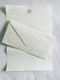 Deckled edge stationery paper sheets with embossed blue monogram and envelope