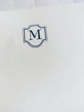 Deckled edge stationery paper sheet with embossed blue monogram